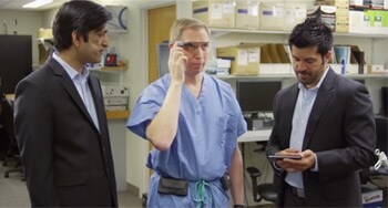 Doctor activating Google Glass while talking with 2 developers.